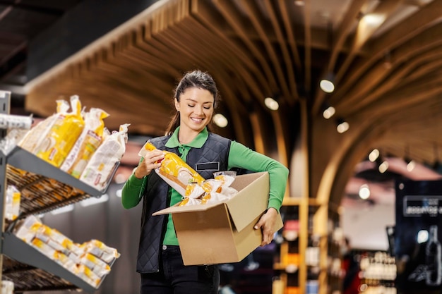 Pracownik umieszczający chleb na półkach w supermarkecie