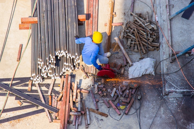 Pracownik używa elektrycznej maszyny do cięcia stali przemysłowej w budownictwie powierzchniowym.