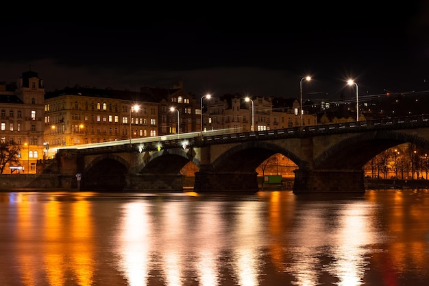 Praga nocą, widok na mosty na rzece Wełtawie, odbicie nocnych świateł miasta, pejzaż