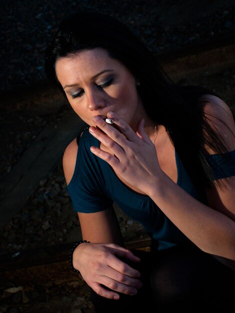 Prawdziwa młoda kobieta pali na wagonach kolejowych.