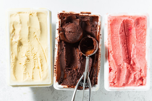Prawdziwe włoskie lody rzemieślnicze w pudełeczku czekoladowym truskawkowym waniliowym z jagodami i łyżką