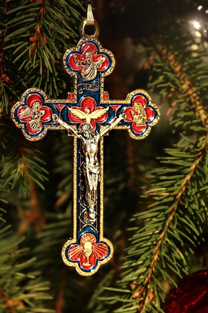 Prawdziwy szczegół choinki z ozdobnym krzyżem Jezusa i czerwonym ornamentem