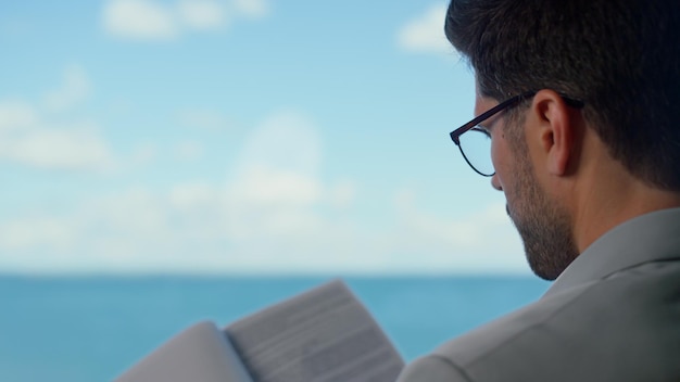 Prawnik studiujący dokumenty kontraktowe w oknie panoramy morza Profesjonalna koncepcja