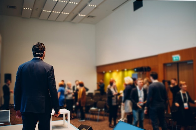 Prelegent na scenie w konferencji biznesowej.