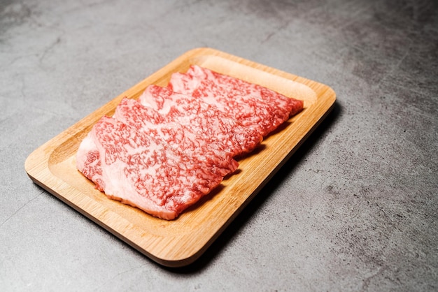 Premium Rare Slices Polędwica Wagyu A5 Z Marmurkową Teksturą Na Drewnianym Talerzu Z Czarnym Tłem Serwowane Dla Yakiniku Sukiyaki I Shabu Zdjęcie Z Miejsca Na Kopię