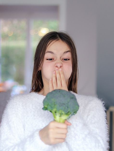 Preteen Dziewczyna Patrząc Na Surowe Brokuły Z Obrzydzeniem Obejmujące Jej Usta