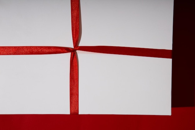 Zdjęcie prezent na święta z czerwoną wstążką na czerwonym tle świąteczne opakowanie