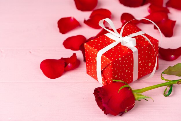Prezent na Walentynki i róża na drewnianym stole z bliska