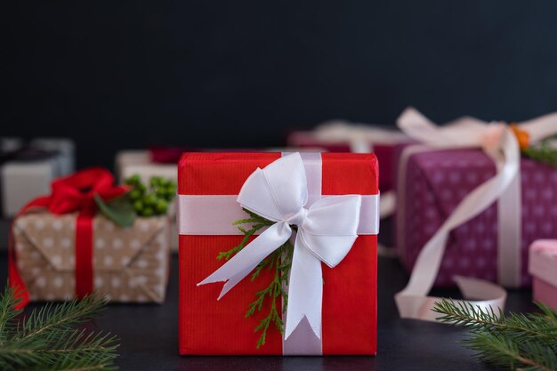 Prezent świąteczny dla wyjątkowej osoby w czerwonym pudełku z pozdrowieniami sezonowymi z białą wstążką i koncepcją obchodów nowego roku