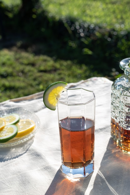 Zdjęcie prezentacja mrożonej herbaty z plasterkiem limonki i światłem zachodzącego słońca