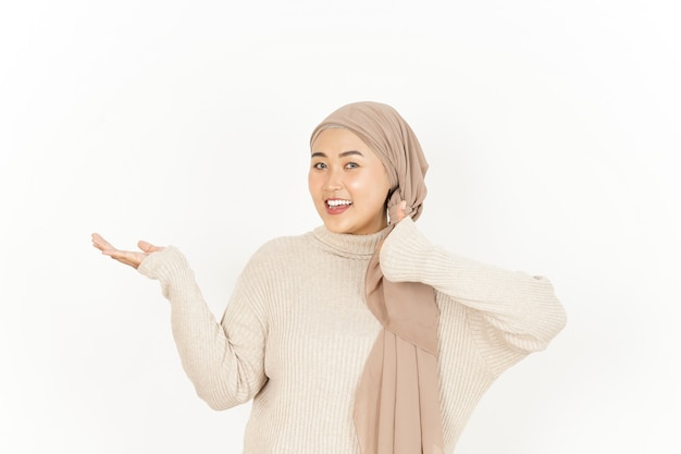 Prezentacja produktu na otwartej dłoni pięknej azjatyckiej kobiety noszącej hidżab na białym tle