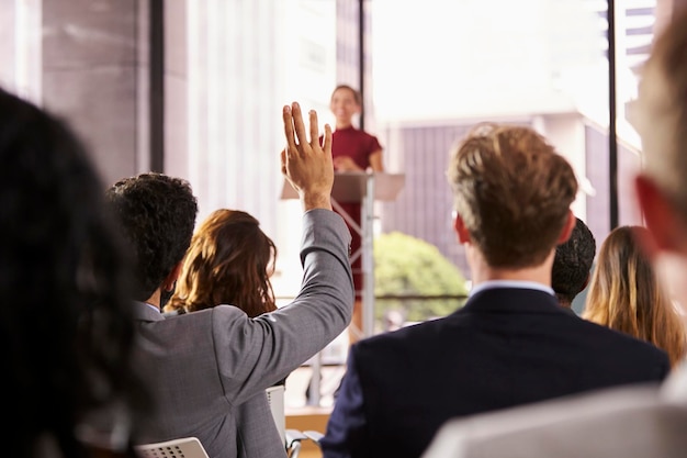 Prezenter na seminarium biznesowym odpowiada na pytanie od publiczności