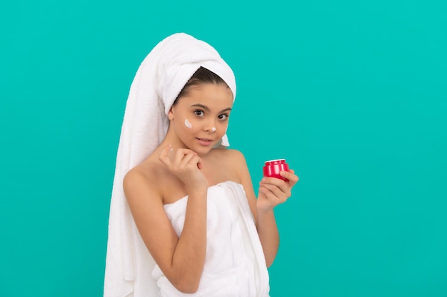 Prezentujemy produkt kosmetyczny dla nastoletniego dziecka użyj krem do twarzy młoda dziewczyna trzymaj maskę do włosów dziecko z kremem do skóry codzienny nawyk i higiena osobista pielęgnacja skóry uroda uroda kosmetyczny peeling oczyszczający nakładanie