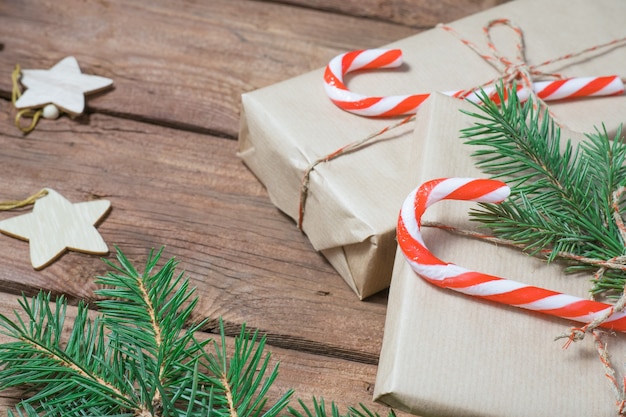 Prezenty świąteczne lub pudełko upominkowe owinięte papierem kraft z dekoracjami szyszki suszone pomarańcze