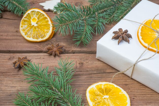 Prezenty świąteczne lub pudełko upominkowe zawinięte w papier pakowy z dekoracjami szyszki sosnowe suche pomarańczowe