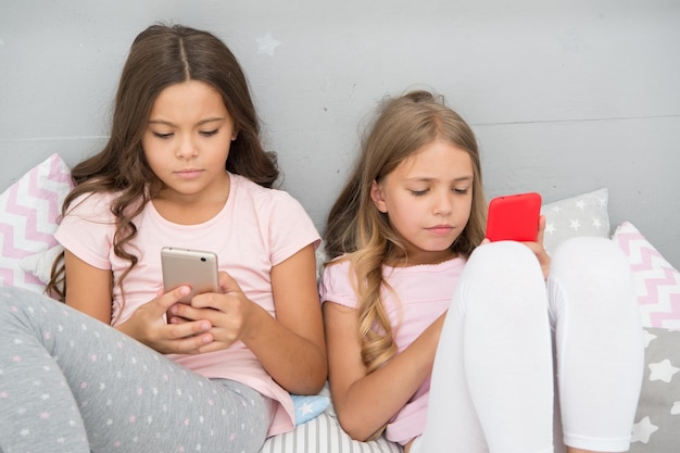 Problem społeczny poranne wibracje na czacie przed snem najlepsze przyjaciółki siostry używają telefonu w łóżku słodkich snów impreza w piżamie w sypialni dzieciństwo z nową technologią surfowanie po internecie dzieci blogują