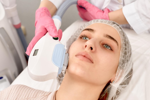 Procedura fotoepilacji w salonie piękności Młoda kobieta otrzymująca depilację Laserowe leczenie twarzy w centrum urody z bliska