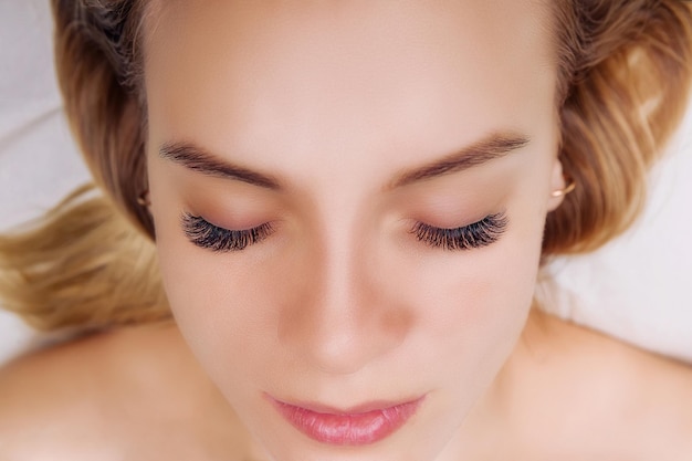 Procedura przedłużania rzęs kobieta oko z długimi niebieskimi rzęsami efekt ombre bliska selektywnej ostrości