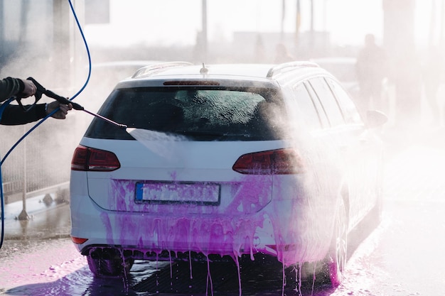 Proces Człowieka Myjącego Samochód W Samoobsługowej Myjni Samochodowej Widok Z Tyłu
