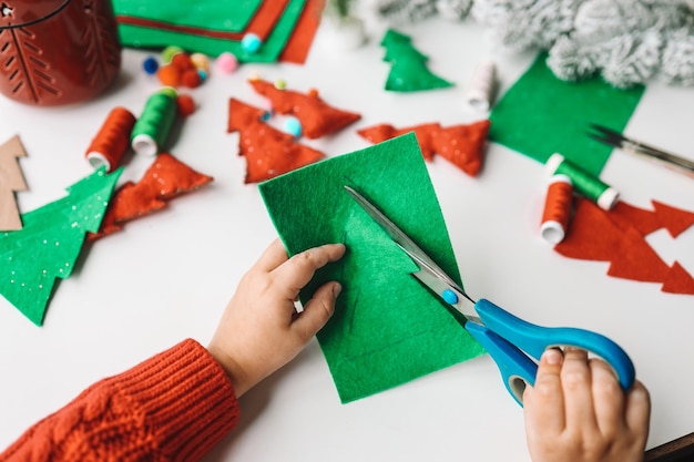 Zdjęcie proces ręcznego szycia miękkich zabawek z filcu i igły do dekoracji choinki bożonarodzeniowej
