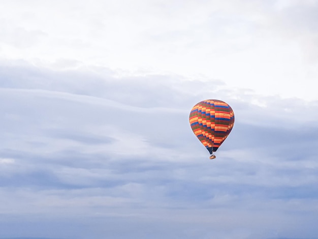 Zdjęcie proces wystrzelenia wielu kolorowych pięknych balonów w powietrze w kapadocji w górach wcześnie o świcie napełnienie balonu gorącym powietrzem z palnika przygotowanie koszyka lot wycieczkowy dla turystów powyżej