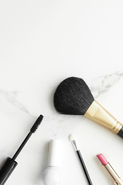 Produkty do makijażu i kosmetyki na marmurowym płaskim tle nowoczesny kobiecy styl życia blog kosmetyczny i...