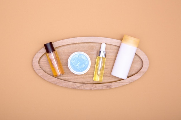 Produkty kosmetyczne na drewnianej tacy na pomarańczowym tle Koncepcja pielęgnacji ciała i włosów na płasko