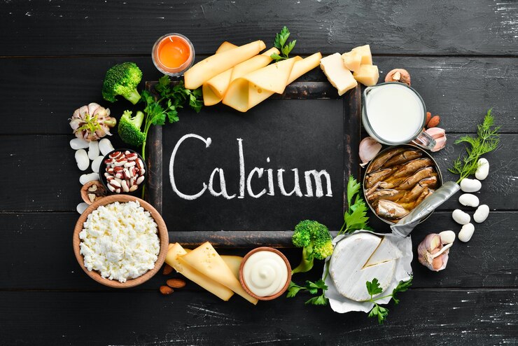 Zdjęcie produkty zawierające naturalny wapń ser mleko parmezan kwaśna śmietana ryby migdały pietruszka czosnek brokuły na czarnym drewnianym tle widok z góry darmowe miejsce na kopię