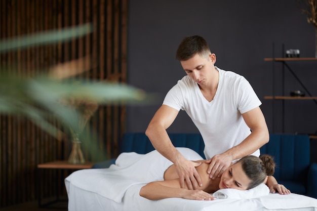 Profesjonalna masażystka leczy pacjentkę w mieszkaniu.