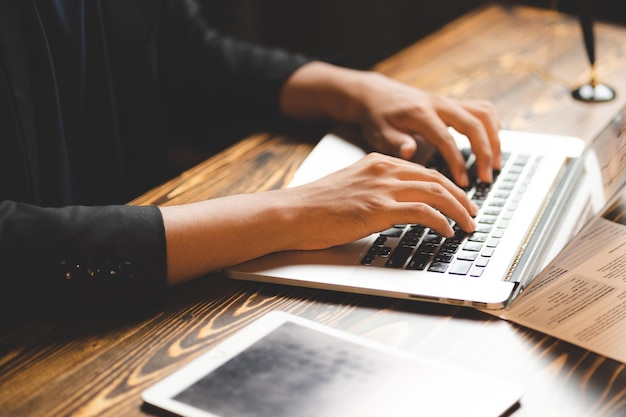 Zdjęcie profesjonalna osoba biznesowa pracuje w komunikacji planu pracy w marketingu online z laptopem, używając ręki do pisania na klawiaturze komputera w nowoczesnym miejscu pracy biurowej lub przestrzeni coworkingowej