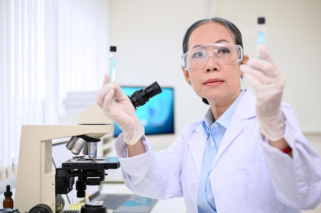 Profesjonalna w wieku azjatycka kobieta-naukowiec lub chemik pracująca w laboratorium