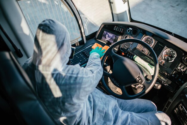 Profesjonalne chemiczne czyszczenie siedzeń autobusowych. Dezynfekcja autobusu. Eksterminator w odzieży roboczej.