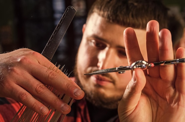 Profesjonalne prace fryzjerskie Mistrz stylu życia fryzjera robi fryzurę i stylizację za pomocą suszarki Concept Barbershop Młody hipster z brodą obcina włosy u fryzjera Hipsterska moda