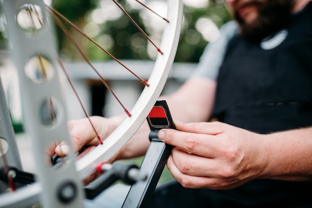 Profesjonalne Ręce Mechanika Rowerowego Dostosowuje Szprychy Rowerowe I Naprawia Koło Z Bliska Narzędzi Serwisowych.