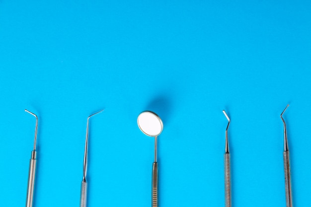 Profesjonalne stalowe instrumenty dentystyczne z lustrem na niebieskim stole