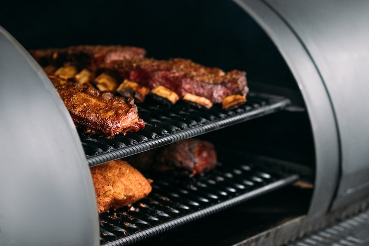 Zdjęcie profesjonalne urządzenie kuchenne. mięso drobiowe, wołowe i wieprzowe, żeberka gotowane na wędzarni bbq.