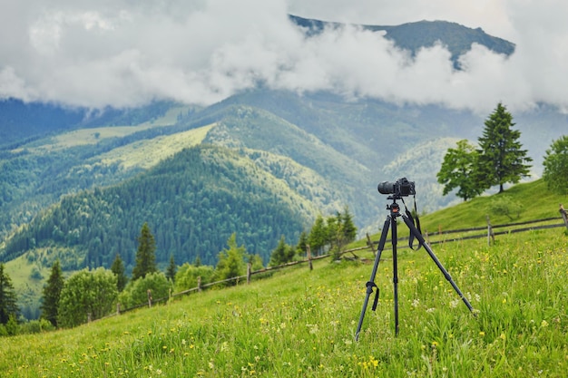 Profesjonalny aparat cyfrowy Dslr stoi na statywie fotografując góry Błękitne niebo i krajobraz chmur