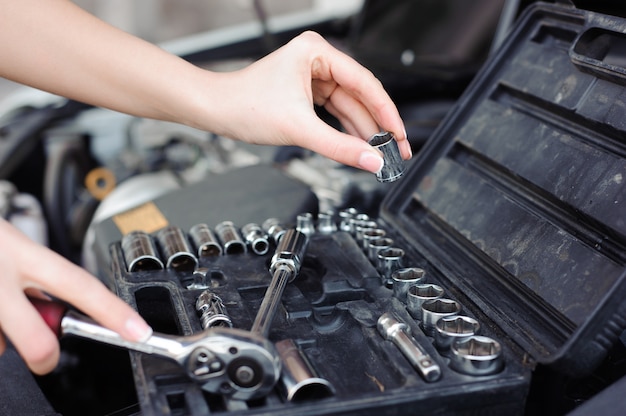 Profesjonalny auto kobieta mechanik i mężczyzna naprawy auto na zewnątrz.