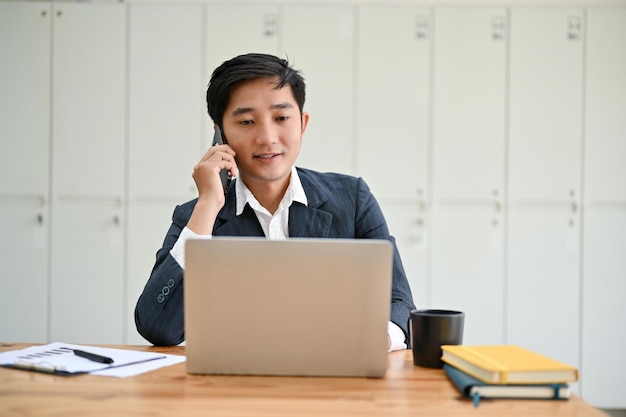 Profesjonalny azjatycki menedżer rozmawia przez telefon ze swoim klientem biznesowym