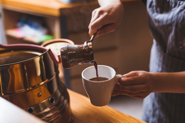 Zdjęcie profesjonalny barista serwujący tradycyjną kawę turecką w kafeterii