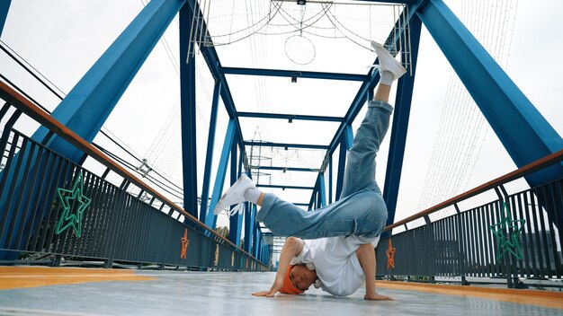 Profesjonalny breakdancer wykonuje taniec uliczny na moście Sprightly