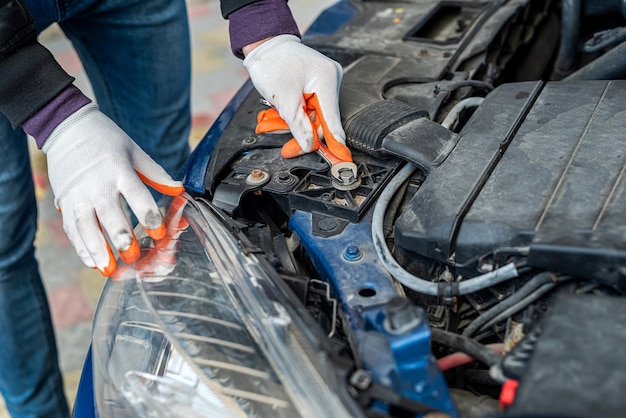 Profesjonalny dobry mechanik w specjalnych rękawiczkach diagnozuje samochód Pojęcie diagnostyki samochodowej