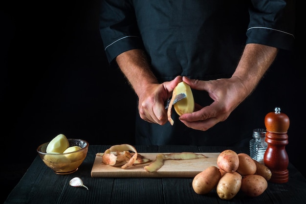Profesjonalny kucharz obiera ziemniaki na frytki Do dań z ziemniaków