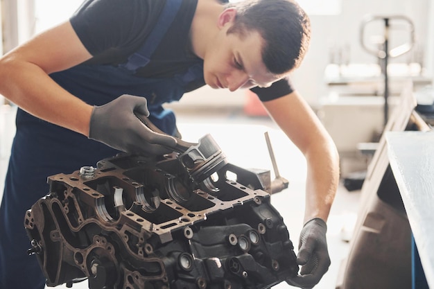 Profesjonalny mechanik pracuje z uszkodzonym silnikiem samochodowym