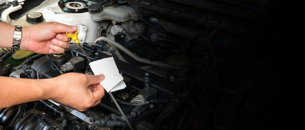 Profesjonalny Mechanik Trzyma Miarkę Poziomu Oleju, Sprawdza Poziom Oleju W Silniku Samochodu, Kopiuje Miejsca