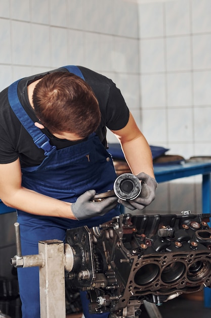 Profesjonalny Mechanik W Czarnej Masce Ochronnej Współpracuje Z Uszkodzonym Silnikiem Samochodowym