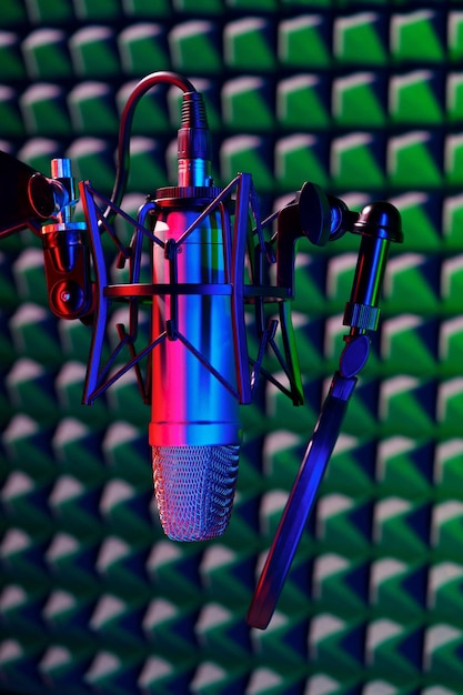 Profesjonalny mikrofon studyjny na tle akustycznego płytki piankowej w świetle neonowym
