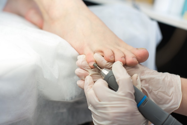 Profesjonalny mistrz pedicure wykonujący pedicure w salonie