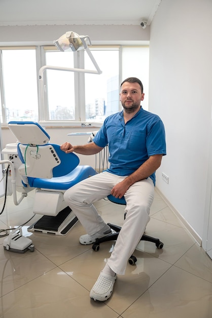 Profesjonalny młody dentysta w odzieży medycznej czeka na swoich pacjentów Koncepcja dentysty bez pacjentów