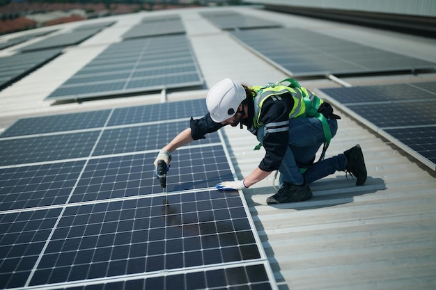 Profesjonalny pracownik instalujący panele słoneczne na dachu domu